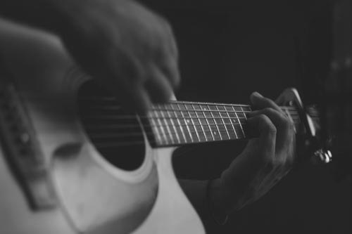 closeup of a person playing the guitar 